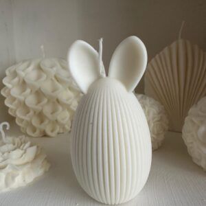 Vela Artesanal Conejo de Pascua – Edición Especial Celebra la Pascua con esta encantadora vela artesanal con forma de huevo y orejas de conejo, elaborada con cera vegetal natural.