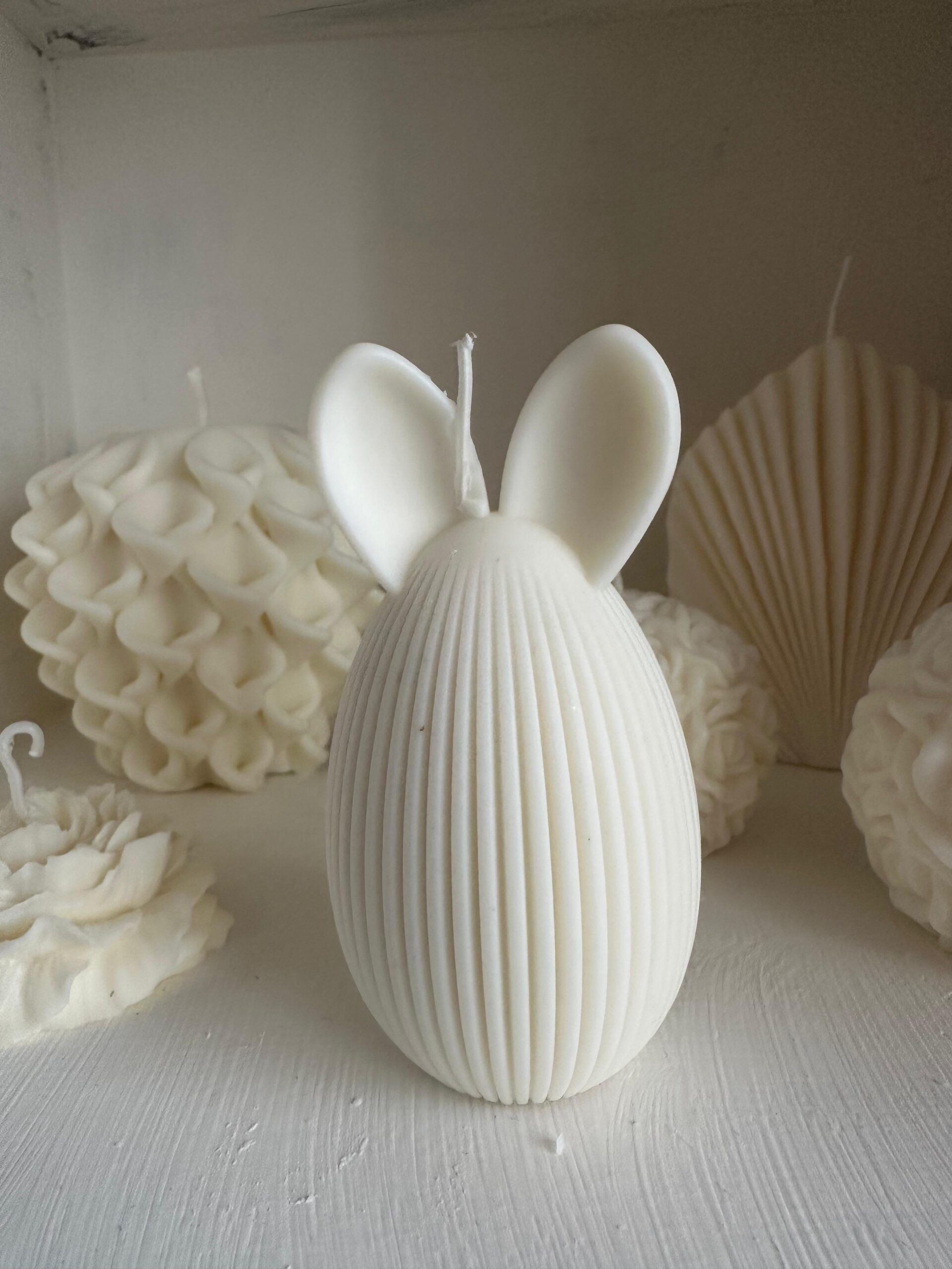 Vela Artesanal Conejo de Pascua – Edición Especial Celebra la Pascua con esta encantadora vela artesanal con forma de huevo y orejas de conejo, elaborada con cera vegetal natural.